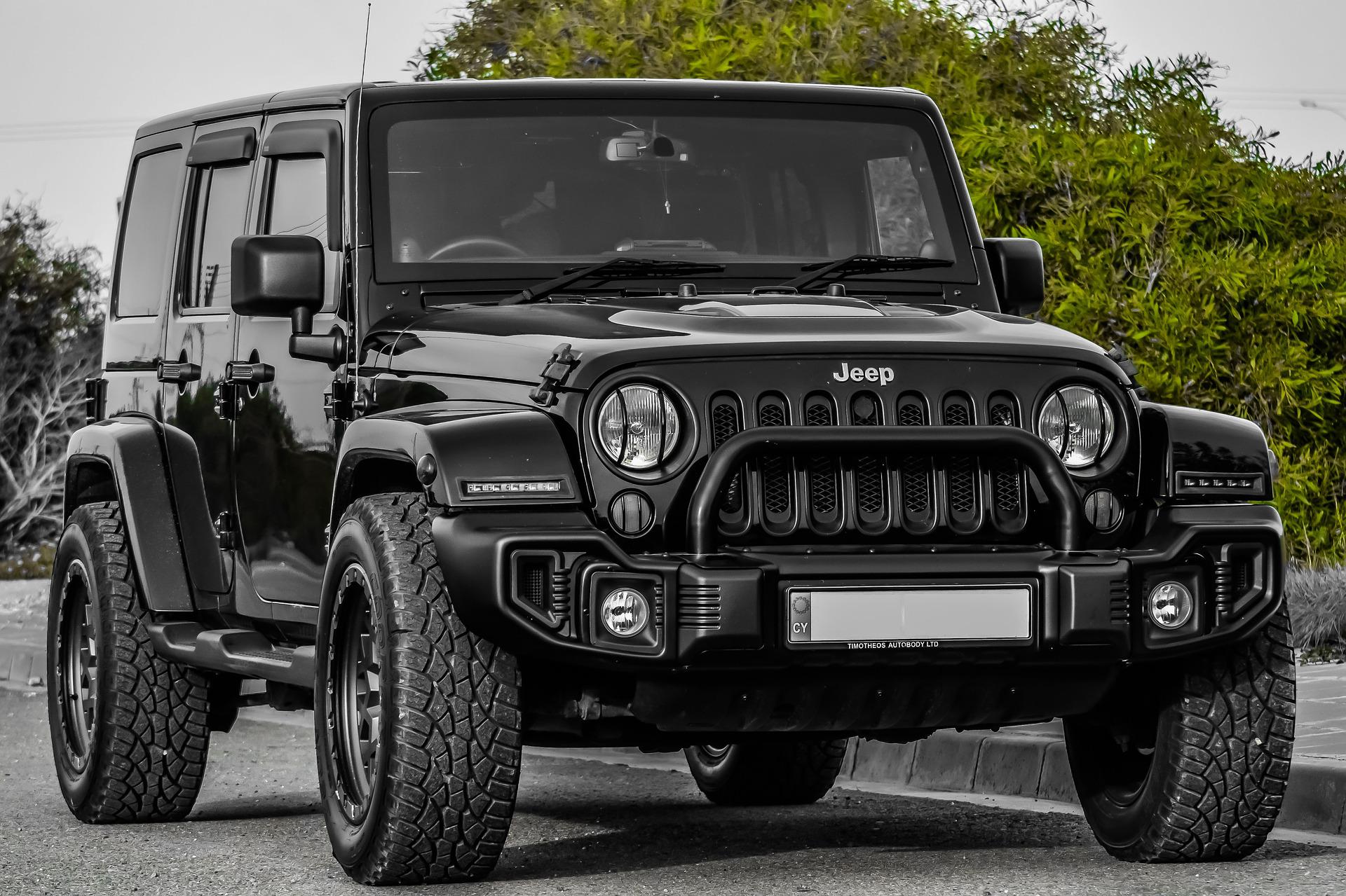 New black Jeep parked on a curb.