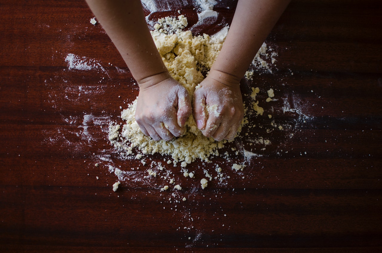 A person kneading dough for scones